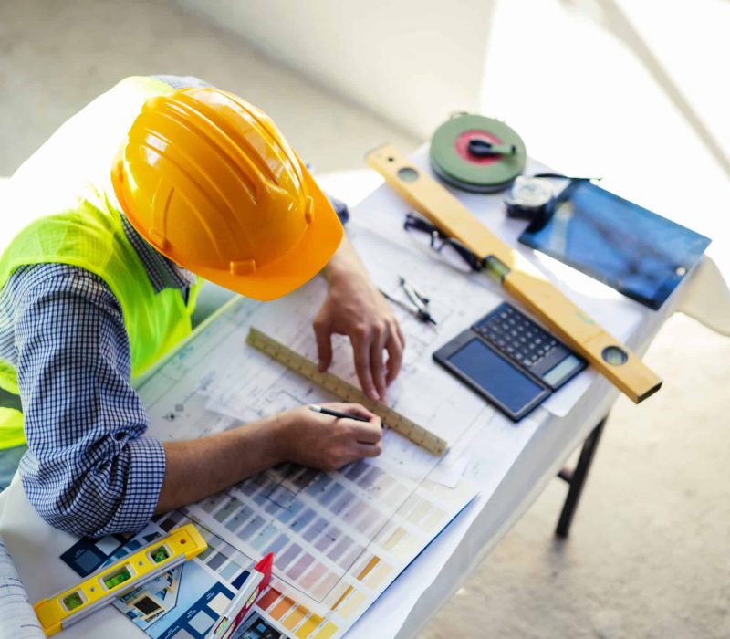 Man architect engineer focus working on blueprint design plan using pencil ruler drawing tool planning analyzing design innovation to building landscape housing architecture. Top view work top.